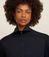 Campera deportiva negra confeccionada en microfibra pesada, con cuello alto doblado, cremallera delantera con cordón en el tirador y puños ajustados.