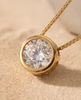 Collar de acero con baño dorado, de cadena fina estilo veneciano, con un dije colgante redondo tipo punto de luz engastado con circonía.