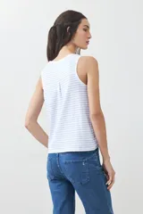 Musculosa blanca con rayas horizontales celestes y escote redondo.