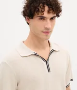 Polo de manga corta con textura en relieve, cuello tipo polo con abertura frontal sin botones y detalles de líneas contrastantes en cuello y puños.