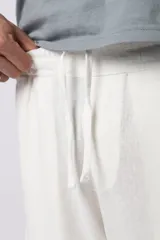 Bermuda cargo de lino y rayón color blanco, con bolsillos laterales tipo cargo, cintura elástica con cordón ajustable y calce relajado.