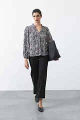 Jean wide leg de color negro, con costuras frontales verticales que estilizan la silueta y cierre frontal con botón metálico.