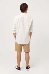 Camisa de manga larga para hombre, color azul claro jaspeado, con cuello clásico y botones blancos. Corte ajustado (slim fit).