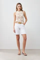 Top tejido crochet color crudo, con cuello halter y espalda descubierta.