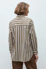 Camisa de corte clásico con estampado de rayas verticales en tonos khaki, blanco y azul. Presenta cuello camisero, cierre frontal con botones, bolsillo en el pecho y mangas largas con puños abotonados.