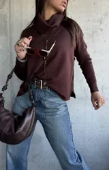 Sweater de tejido de punto color chocolate, con cuello polera, mangas largas con puños acanalados y diseño holgado con aberturas laterales y detalle de botones.