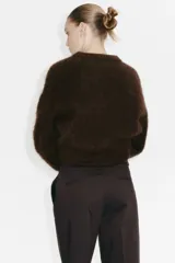 Pantalón tobillero de color marrón oscuro, corte recto y ajustado, con cintura estándar y bolsillos al bies.