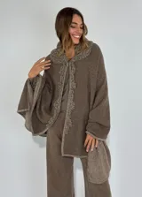 Ruana de lambswool color marrón, con cuello y detalles bordados a mano en el frente.