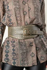 Cinto ancho color verde militar, con elástico en la parte trasera y cuero en la parte delantera. Presenta hebilla metálica dorada y tachas doradas.