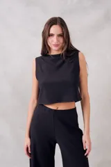 Top negro de algodón y poliéster, corte crop y cuello redondo.