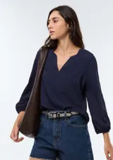 Blusa de viscosa color marrón con escote en V, mangas tres cuartos con puños elásticos y corte holgado.