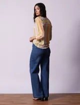 Blusa estampada de Zac & Rachel con cuello a la base, escote en V y botones. Tiene un bolsillo aplicado en la parte delantera, mangas largas regulables con presilla y botón, y terminación anudada opcional.