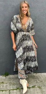 Vestido largo en tonos azules con estampado paisley, escote en V delantero y trasero, corte con elástico debajo del busto y mangas cortas holgadas.