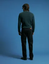 Remera de punto tipo polo con textura waffle, color verde petróleo, de manga larga y cuello con cierre de botones.