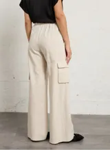 Pantalón ancho color beige a rayas con bolsillos cargo laterales y cintura elástica.