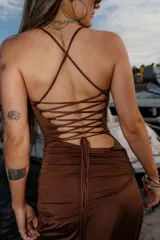 Vestido largo color marrón chocolate, con breteles finos, escote recto y fruncido lateral. Presenta un tajo lateral en la falda.