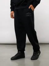 Pantalón jogger de felpa sin frisa, color gris claro melange, con logo bordado de Umbro en azul oscuro en el muslo izquierdo y puños elásticos en los tobillos.