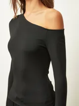 Top de manga larga color negro, con diseño asimétrico de un solo hombro descubierto y corte ajustado al cuerpo.