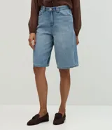 Bermuda estilo jorts de cintura alta, confeccionada en denim de algodón con lavado clásico, trabillas para cinturón, cierre frontal con botones y bolsillos funcionales.