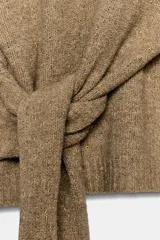 Jersey de punto con cuello perkins, manga larga con puños ajustados y detalle de lazada en la cintura.