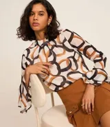 Blusa de mangas largas de chiffon, con cuello alto y cierre por gota. Estampa de eslabones entrelazados con detalles de pequeños corazones.