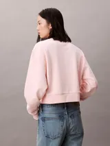 Buzo cropped de cuello redondo, confeccionado en algodón, con puños y dobladillo en punto canalé. Presenta un diseño minimalista con detalle de costura en V en el cuello.