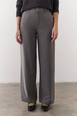 Pantalón marrón de corte recto y pierna ancha, con cintura alta, bolsillos laterales y cierre.