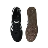 Championes Adidas modelo Handball Spezial, de diseño clásico con exterior de gamuza negra, tres bandas laterales blancas y suela de goma color caramelo. Incluye el nombre del modelo en letras doradas en el lateral.