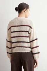 Sweater de tejido de punto grueso con diseño de rayas horizontales en tonos azul y rojo sobre base color natural, cuello redondo y mangas largas.