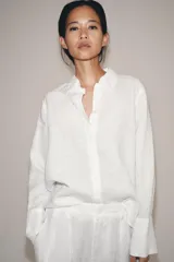 Camisa de lino de corte clásico con cuello solapa, manga larga con puños anchos y cierre frontal con botones.