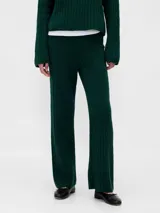 Pantalón de punto con textura de trenzas, de corte recto y tiro medio. Presenta un diseño tejido en color verde oscuro.
