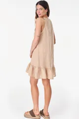 Vestido corto lila de lino, sin mangas, con escote redondo, cartera de botones de nácar en el frente y volado fruncido en el ruedo.