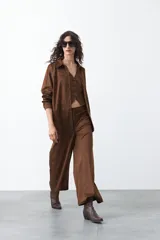 Pantalón ancho de gamuza color marrón, de calce relajado y caída suave.