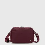 Riñonera Bubba de diseño rectangular, confeccionada en tela resistente color bordó. Cuenta con cierre superior doble, correa ajustable para llevar cruzada o a la cintura y un bolsillo trasero con cierre.