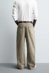 Pantalón de corte baggy fit confeccionado en tejido de algodón con textura y efecto lavado. Presenta diseño de cinco bolsillos, cierre frontal con cremallera y botón.