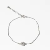 Pulsera plateada de cadena fina con dije circular con circonitas engarzadas.