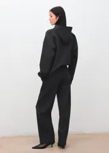 Pantalón de vestir gris oscuro, de corte recto y holgado, con tiro medio y costuras frontales marcadas en las piernas.
