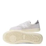Championes urbanos New Balance modelo Court, color beige con detalles en crema y suela de goma con efecto envejecido. Presentan el logo N característico en los laterales y perforaciones en la puntera para mayor ventilación.