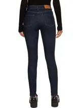 Jeans de calce ajustado color azul oscuro, con diseño de cinco bolsillos, cierre de botón y cremallera, detalles distintivos de Tommy Hilfiger y logo sobre el bolsillo posterior.