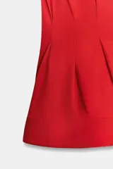 Camisa de cuello solapa y manga sisa, de color blanco. Presenta bajo acabado en peplum y cierre frontal con botones ocultos.