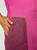 Pollera larga de lino color fucsia con paneles laterales en color borgoña y bolsillos laterales.