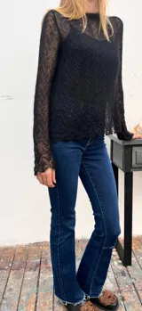 Sweater de punto calado confeccionado en 100% mohair italiano, con cuello redondo y mangas largas. Presenta una textura aireada y delicada con un diseño etéreo y sofisticado.