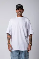 Remera blanca de corte oversize, manga corta y cuello redondo. Presenta un pequeño estampado en la parte inferior delantera y un gráfico grande en la espalda.