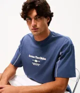 Remera de algodón color azul con corte boxy, cuello redondo y mangas cortas. Presenta una estampa frontal con lettering en color blanco y costuras decorativas en contraste a lo largo de las mangas.