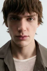 Trench color verde militar, de corte oversized, con cuello con solapas de muesca y manga larga con puño y trabilla. Presenta bolsillos de plastrón con solapa en la cadera y un bolsillo interior. Tiene una abertura en el centro de la espalda y cierre frontal de botonadura cruzada.