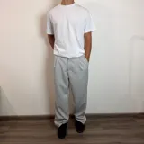 Pantalón sastrero color beige, de corte baggy, con pliegues en la cintura y bolsillos laterales.