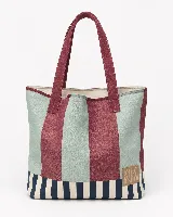 Bolso tipo tote con diseño de rayas verticales anchas en tonos bordó y verde agua, con una franja inferior de rayas más finas en azul marino y crema. Cuenta con manijas largas en color bordó y un parche de cuero sintético con logo grabado en la parte inferior.