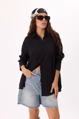 Camisa negra de muselina, corte holgado, manga larga y botones al tono.