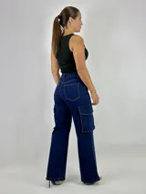 Pantalón jean azul oscuro, corte wide leg, con bolsillos cargo laterales.