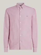 Camisa de corte slim confeccionada en algodón Oxford con textura dobby. Presenta cuello con botones, puños redondeados y el logo de Tommy Hilfiger bordado en el pecho.